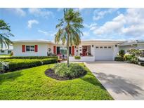 Charming single-story home with a well-manicured lawn, red shutters, and vibrant landscaping at 3800 101St N Ter # 3800, Pinellas Park, FL 33782