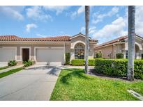 Charming home with red tile roof, well-manicured lawn, and attached two-car garage at 3885 Timber Ridge Ct, Palm Harbor, FL 34685