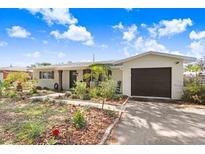 Charming single-story home featuring a well-manicured front yard with a driveway and attached garage at 6154 36Th N Ave, St Petersburg, FL 33710