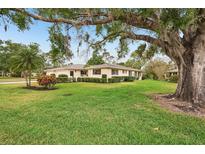 Charming home featuring a lush green lawn, mature trees, and well-maintained landscaping at 7094 Fairway Bend Cir # 7094, Sarasota, FL 34243