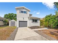 Charming home featuring a gray exterior, matching shed and an attached one-car garage at 7134 2Nd N St, St Petersburg, FL 33702
