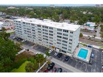 Aerial view of a condo community showcasing parking, pool and mature trees in a desirable area at 7321 Central Ave # 203, St Petersburg, FL 33710