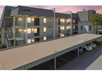 A charming multi-level condominium complex with covered parking and balconies at sunset, offering convenient and stylish living at 8703 Bardmoor Blvd # 203, Seminole, FL 33777