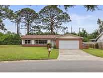 Charming single-story brick home featuring a two-car garage, manicured lawn, and mature trees at 14006 79Th Ave, Seminole, FL 33776
