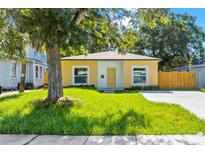 Charming yellow home with a well-maintained lawn, mature tree, and a new concrete driveway at 1432 19Th S St, St Petersburg, FL 33712