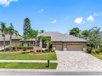 Charming single-story home with a three-car garage, stone accents, and lush landscaping in a suburban neighborhood at 16529 Ivy Lake Dr, Odessa, FL 33556