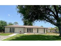 Charming single-story home with a well-manicured lawn and mature tree providing ample shade at 24549 Nova Ln, Punta Gorda, FL 33980