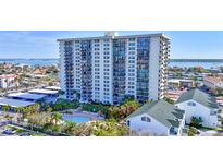 A striking view of a modern, high-rise condo building, featuring a pool and covered parking at 400 Island Way # 201, Clearwater Beach, FL 33767