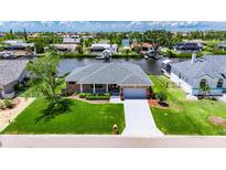 Beautiful waterfront home with lush green lawn and well-manicured landscaping at 829 Golf Island Dr, Apollo Beach, FL 33572