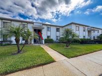 Condo building featuring manicured landscaping and palm trees for a tropical feel at 110 W Cypress Ct, Oldsmar, FL 34677