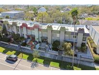 Aerial view of townhome complex with landscaped grounds and colorful rooftops near street parking at 166 E Davis Blvd, Tampa, FL 33606
