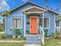 Charming blue home with an inviting covered porch and a vibrant orange front door at 2425 Auburn S St, St Petersburg, FL 33712