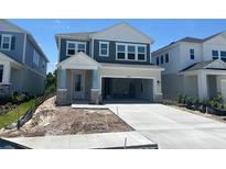 Charming two-story home with light blue siding, white trim, and a spacious two-car garage at 28764 Jujube Rd, Wesley Chapel, FL 33543