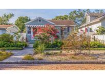 Charming single-story home featuring mature landscaping with colorful blooming plants on a brick-paved street at 4426 3Rd N Ave, St Petersburg, FL 33713