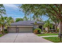 Lovely single-story home boasts a three-car garage and meticulously landscaped front yard at 6205 Ibispark Dr, Lithia, FL 33547