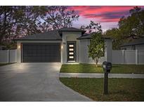 Charming home features a modern front door, well-manicured lawn, and a spacious two-car garage at 6302 N 39Th St, Tampa, FL 33610
