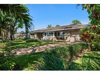 Beautiful single story home with a well-manicured lawn and a brick driveway at 7909 Garden N Dr, St Petersburg, FL 33710