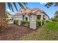 Charming home featuring a red tile roof and tropical landscaping at 9897 Sago Point Dr, Seminole, FL 33777