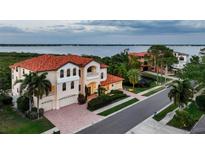 Stunning Mediterranean home with tile roof, manicured landscaping, and picturesque water views from multiple levels at 109 Wateredge Ct, Safety Harbor, FL 34695