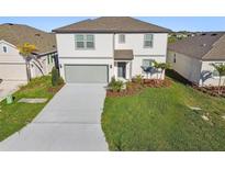 Two-story home showcasing a manicured lawn, gray trim, complementing the gray garage door at 11022 Moonsail Dr, Parrish, FL 34219