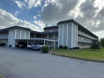 A condo exterior shot of the building with a parking garage at 1220 57Th N St # 204C, St Petersburg, FL 33710