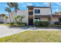Inviting two-story condo with mature landscaping, tropical foliage, and a private balcony overlooking lush front yard at 2205 Belleair Rd # A24, Clearwater, FL 33764