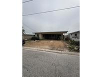 Modest single-story home with gravel yard and covered parking area, showing potential for renovation at 249 144Th Ave, Madeira Beach, FL 33708