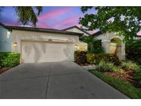 Charming home with a two-car garage and well-manicured landscaping at sunset at 8248 Sequester Loop, Land O Lakes, FL 34637