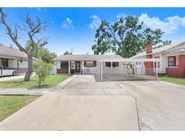 Charming single-story home featuring a covered carport and a well-maintained front yard on a sunny day at 1054 13Th S Ave, St Petersburg, FL 33705