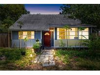 Charming single-story home with a red door, stone path, and manicured landscaping at 1591 S Prospect Ave, Clearwater, FL 33756