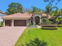 Beautiful single-story home with a well-manicured lawn and lush landscaping, featuring a three-car garage at 1819 Bella Casa Ct, Tampa, FL 33618