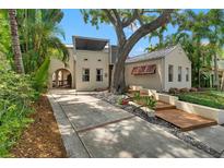 Charming home exterior featuring a lush garden, mature trees, and a welcoming walkway at 326 16Th Ne Ave, St Petersburg, FL 33704