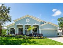 Charming single-story home with arched entryway and lush landscaping on a sunny day at 4007 Canter Ct, Valrico, FL 33596