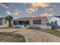 Charming home featuring a cozy screened-in porch and a well-kept front yard at 440 S Bayshore Dr, Madeira Beach, FL 33708