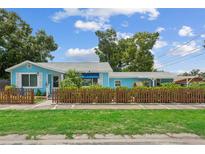 Charming light-blue home with a well-maintained lawn and decorative brown picket fence enhancing the curb appeal at 500 45Th S St, St Petersburg, FL 33711