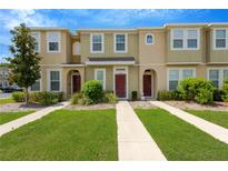 Inviting townhome exteriors with manicured lawns and sidewalks leading to each front door at 7029 White Treetop Pl, Riverview, FL 33578