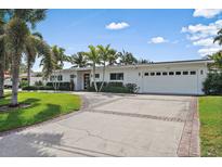 Charming home featuring a lush front yard, brick-lined driveway, and well-maintained landscaping at 1112 38Th Ne Ave, St Petersburg, FL 33704