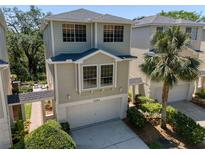 Charming two-story townhouse features a garage, landscaped yard and walkway with covered patio at 1353 Curlew Rd, Dunedin, FL 34698