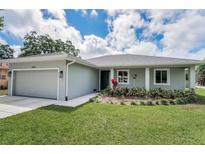 Charming single-story home with a well-manicured lawn and an attached garage at 1453 Otten St, Clearwater, FL 33755