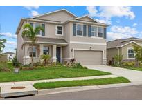 Charming two-story home with a well-maintained lawn, neutral paint, a two-car garage, and decorative blue shutters at 17923 Cantarina Cv, Bradenton, FL 34211