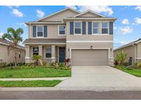 Charming two-story home with a well-maintained lawn, neutral paint, a two-car garage, and decorative blue shutters at 17923 Cantarina Cv, Bradenton, FL 34211