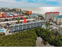 Beautiful aerial view of beachfront condos with balconies overlooking waterway near the ocean in a desirable location at 19727 Gulf Blvd # 207, Indian Shores, FL 33785