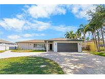 Charming single-story home with a well-manicured lawn, circular driveway, and an attached two-car garage at 200 98Th Ne Ave, St Petersburg, FL 33702