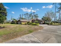 Beautiful single-story home with a large yard, mature trees, and a long driveway at 29844 Baywood Ln, Wesley Chapel, FL 33543
