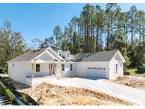 An elegant home boasting a brick driveway, a two-car garage, and a blend of modern and country-style architecture at 3926 Southern Valley Loop, Brooksville, FL 34601