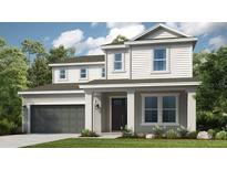 Charming two-story home with a gray stucco finish, well-manicured lawn, and an attached two-car garage at 5128 Slate Hue Pl, Apollo Beach, FL 33572