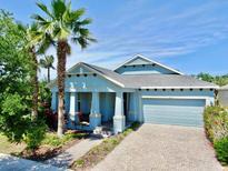 Charming single-story home with a paver driveway, a two-car garage, and a beautifully landscaped front yard at 5239 Admiral Pointe Dr, Apollo Beach, FL 33572