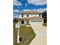 Two-story home with a two-car garage, manicured lawn and charming curb appeal at 7044 Brickell Ct, Spring Hill, FL 34609
