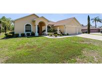Charming single-story home with a well-manicured lawn and a three car garage at 5202 Lydia Ct, Spring Hill, FL 34608