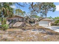 Charming single-story home with a mature tree-lined yard and brick accent, creating a serene and inviting curb appeal at 1250 12Th Sw Ct, Largo, FL 33770
